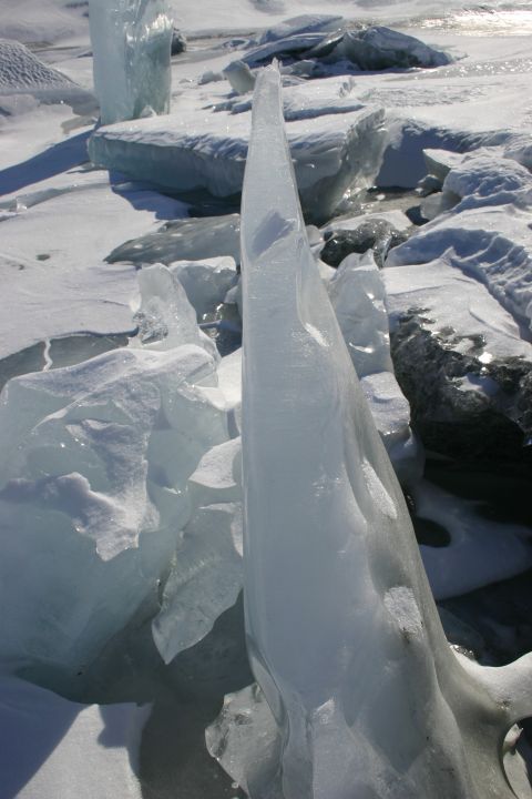 2003 Jeep TJ - A dramatic ice formation stands tall amidst a frozen, snow-covered landscape, likely a glacier or icy terrain.