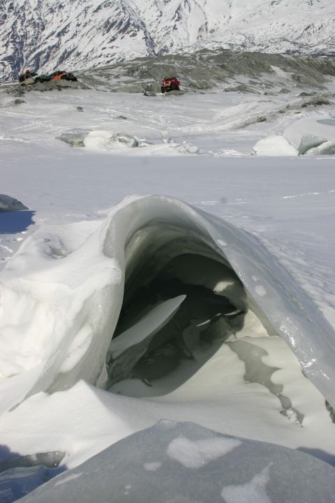 2003 Jeep TJ - Ice cave entrance in a snowy landscape with mountains in the distance.