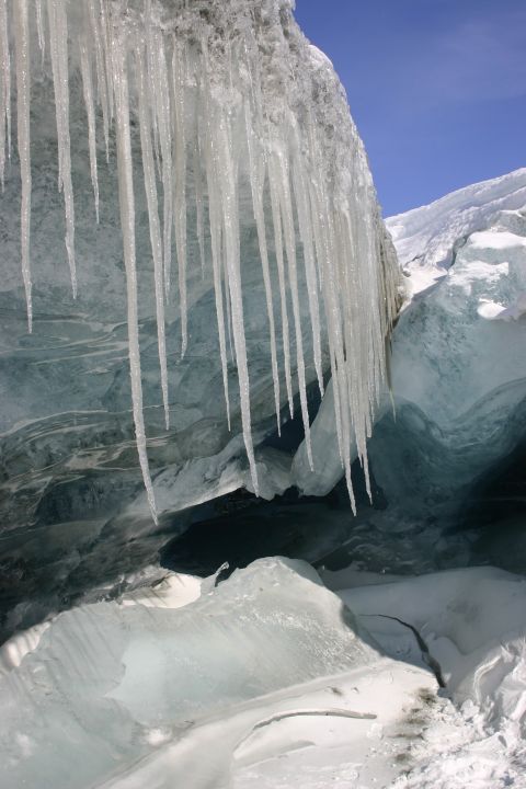 2003 Jeep TJ - Icicles hang from the ceiling of a glacial ice cave, with a bright blue sky overhead.