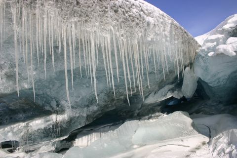 2003 Jeep TJ - Icicles hang from an icy overhang within a cave, with snow and ice formations visible.