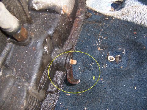 1987 Ford Bronco - A close-up view of the vehicle's interior floor shows a metal bracket and bolt on the carpeted surface.
