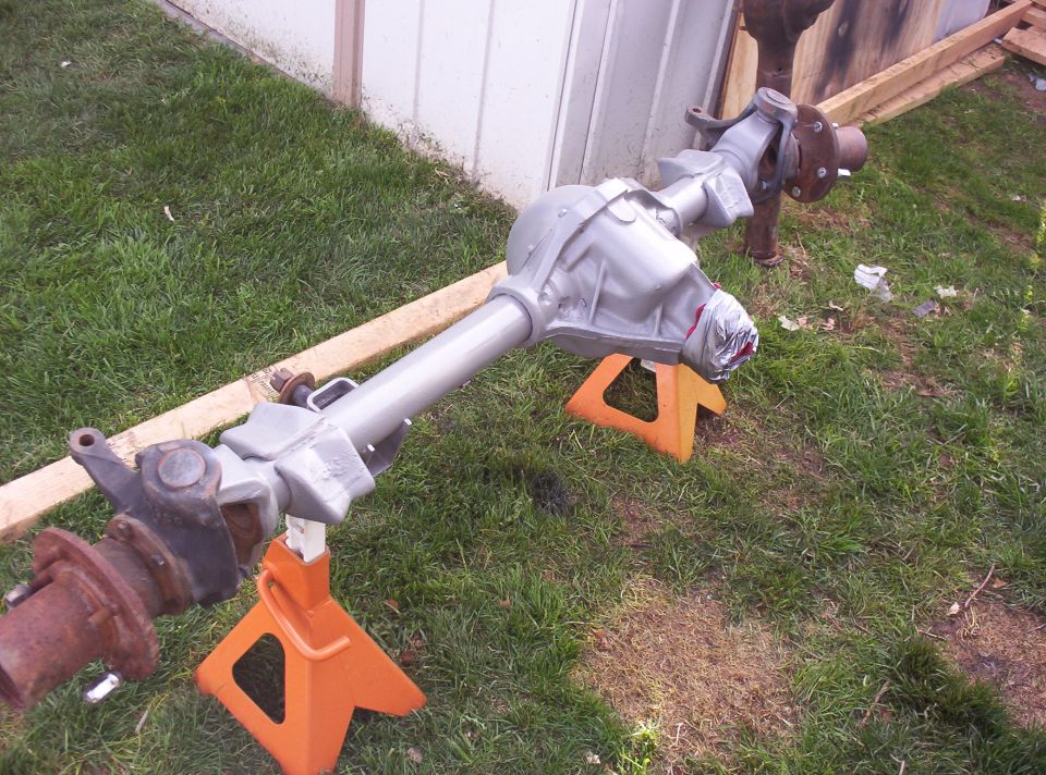vehicle axle assembly on jack stands in grass