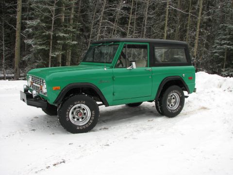 1975 Ford Bronco - A green 1975 Ford Bronco sits in the snow, ready for winter adventures.