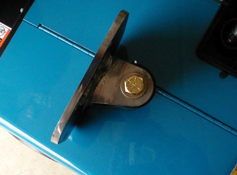 1996 Ford Bronco - A metal bracket with a bolt is shown against a bright blue background.