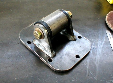 1996 Ford Bronco - A custom metal bracket with rubber dampeners and hardware is shown on a work surface.