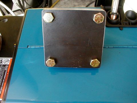 1996 Ford Bronco - Close-up of a metal plate attached with bolts to a piece of blue machinery.
