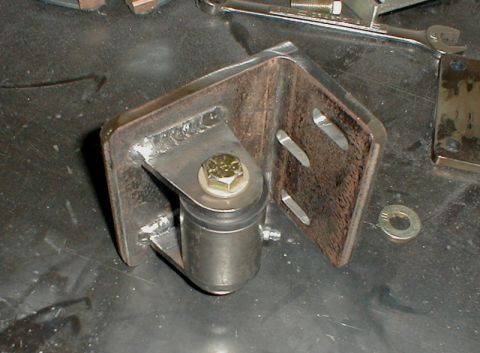 1996 Ford Bronco - A metal bracket assembly with a bolt and washer is shown on a dark surface.