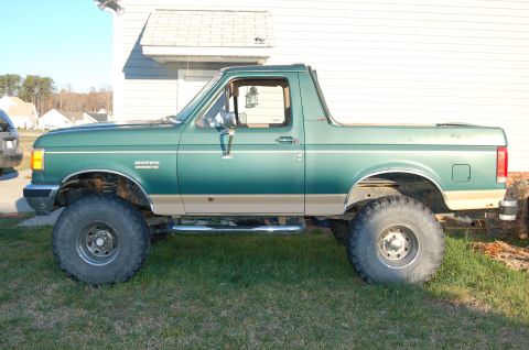 1987 Ford Bronco - This lifted 1987 Ford Bronco features a two-tone green and tan paint scheme and aggressive off-road tires.