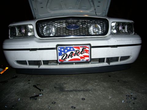 2000 Ford Crown Victoria - The front grille and headlights of a Ford Crown Victoria are visible, with a D.A.R.E. license plate mounted on the bumper.
