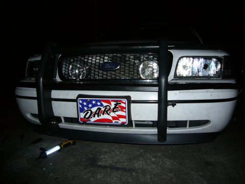 2000 Ford Crown Victoria - The front grille and headlights of a Ford Crown Victoria are visible, along with a D.A.R.E. license plate and a push bar.