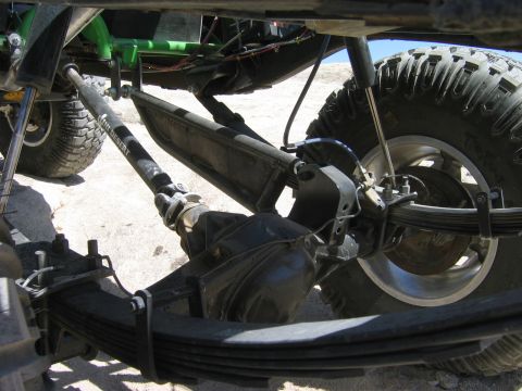 1985 Ford Bronco - Close-up view of the suspension and drivetrain components of a modified off-road vehicle.