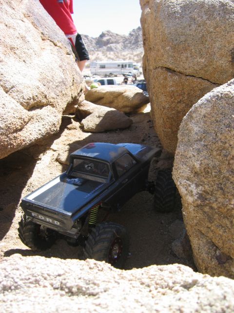 1985 Ford Bronco - A remote-controlled truck maneuvers through a challenging off-road course with large boulders.