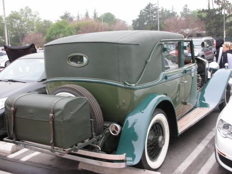 1998 Ford Crown Victoria - A classic green convertible with a trunk rack and spare tire is parked next to modern vehicles.