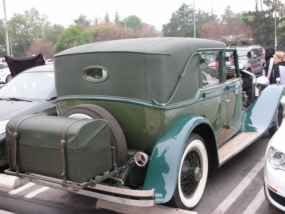 Vintage green coachbuilt convertible sedan with side-mount spare and whitewalls