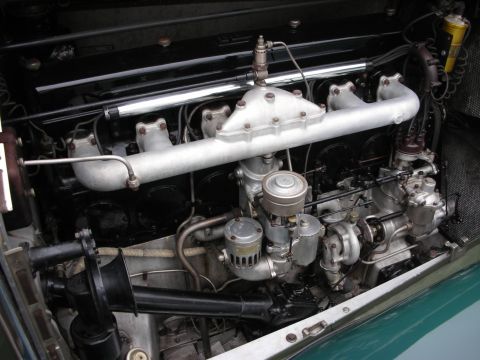 1998 Ford Crown Victoria - Close-up view of an engine compartment, showing various mechanical components and a green fender.