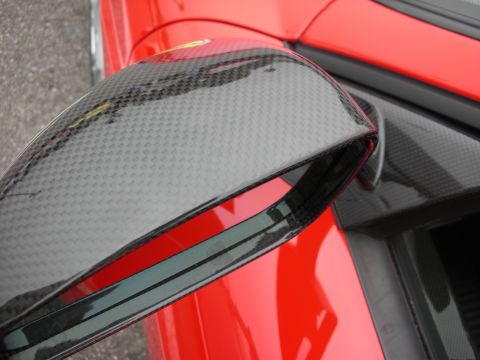 1998 Ford Crown Victoria - Close-up of a red vehicle's side mirror with a carbon fiber finish.