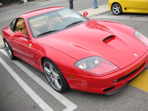 1998 Ford Crown Victoria - A red Ferrari 360 Modena is parked in a lot next to a yellow car.
