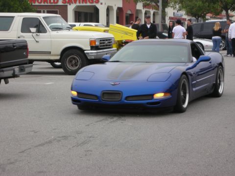 1998 Ford Crown Victoria - Blue Chevrolet Corvette C5 seen at a coffee meet, parked near a white Ford Bronco.