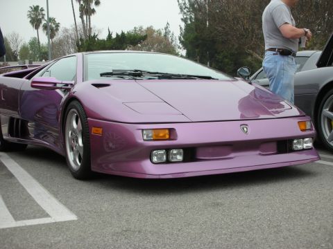 1998 Ford Crown Victoria - A purple Lamborghini Diablo is parked in a lot, with a person standing nearby.