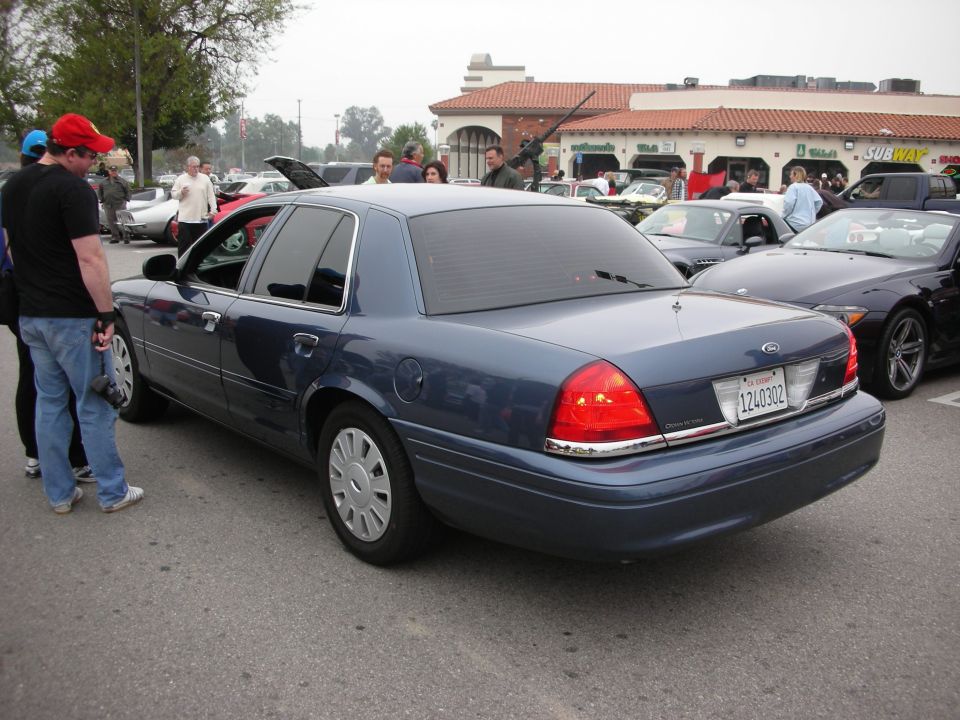 Rear of a dark blue Ford Crown Victoria sedan at a car show