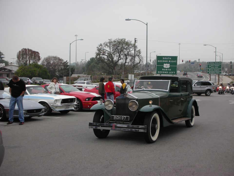 Vintage green Rolls-Royce sedan with BGH 97 plate at intersection