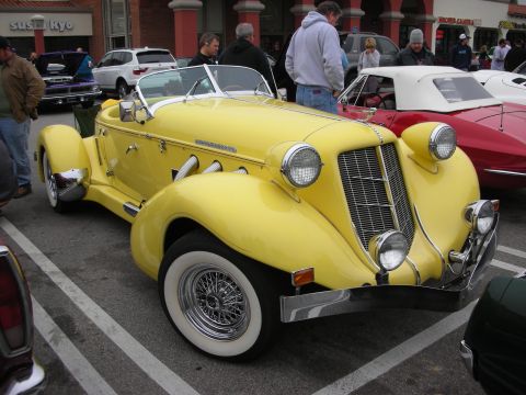 1998 Ford Crown Victoria - A bright yellow classic convertible is parked at an outdoor event with other vehicles around.