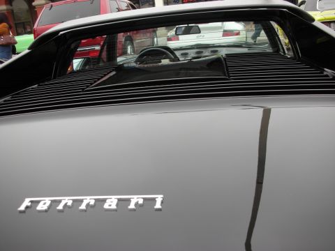 1998 Ford Crown Victoria - The rear of a black Ferrari is shown, with other vehicles in the background.