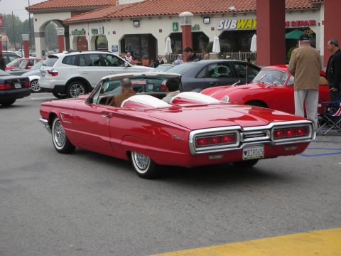 1998 Ford Crown Victoria - A red convertible is parked in front of a Subway restaurant, with other vehicles around.