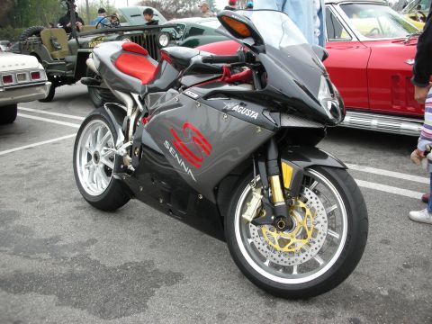 1998 Ford Crown Victoria - A striking MV Agusta F4 Senna motorcycle with its distinctive gray and red livery is showcased at a car meet.