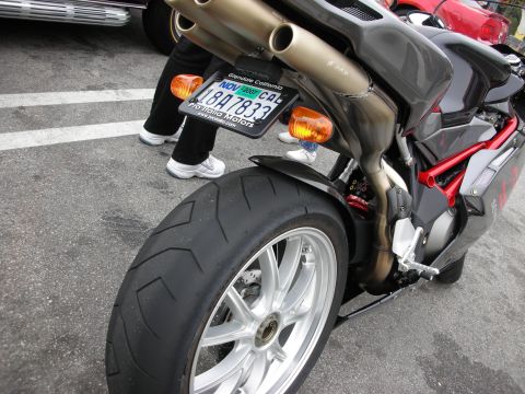 1998 Ford Crown Victoria - Close-up of a motorcycle's rear tire and exhaust system, with a California license plate visible.