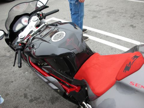 1998 Ford Crown Victoria - A close-up view of a black sport motorcycle with a red seat and red frame details, parked outdoors.