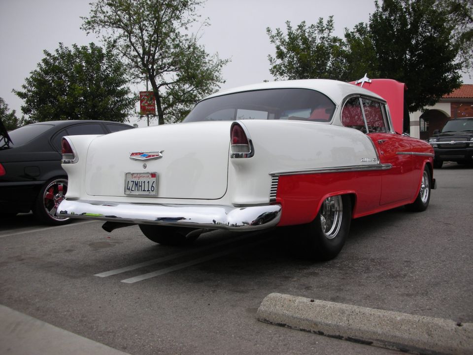 Red and white 1955 Chevrolet Bel Air hardtop rear three-quarter