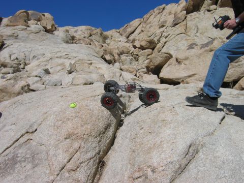 1985 Ford Bronco - A person operates a remote-controlled rock crawler navigating a challenging rocky landscape.