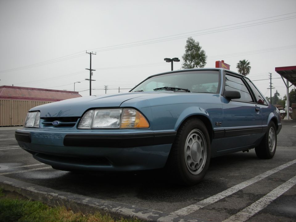 Blue 1990 Ford Mustang parked in a lot