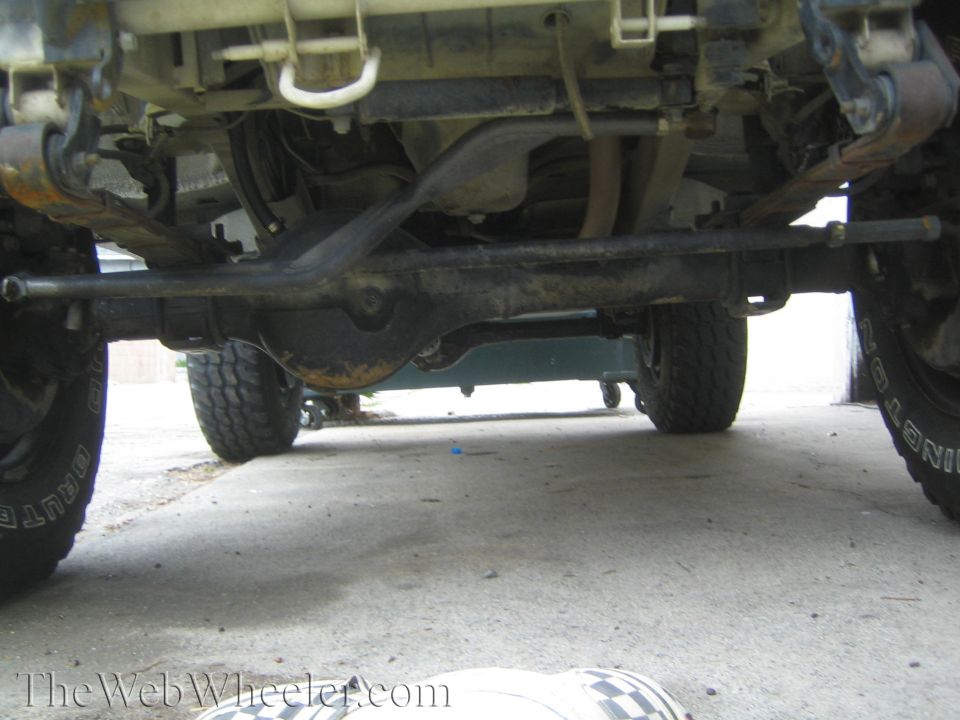 Under-vehicle view of a solid front axle, differential, tie rod and leaf springs on a 4x4