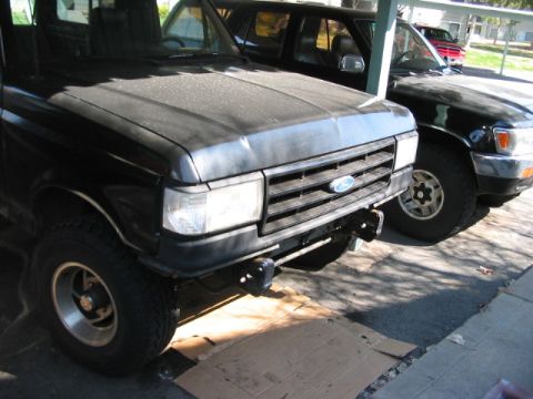 1991 Ford Bronco - 1991 Ford Bronco and another SUV parked under a carport.