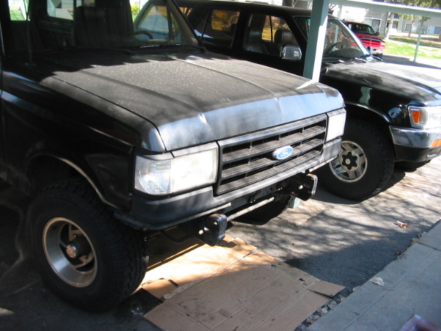 Front view of a 1991 Ford Bronco parked next to a black SUV