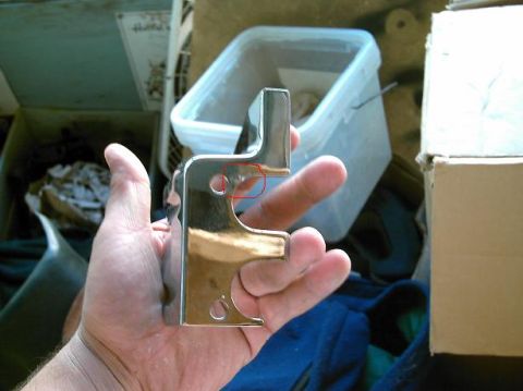 1986 Ford Bronco - A person is holding a polished metal bracket, possibly a car part, with a red circle highlighting a detail.