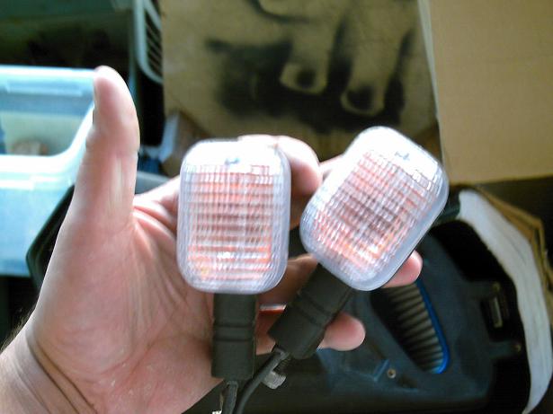 Pair of amber turn signal lights held in hand