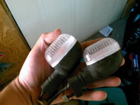 1986 Ford Bronco - Pair of motorcycle turn signal assemblies being held.