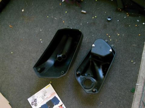 1986 Ford Bronco - Two black plastic air cleaner housings are shown on a carpeted surface with scattered debris.
