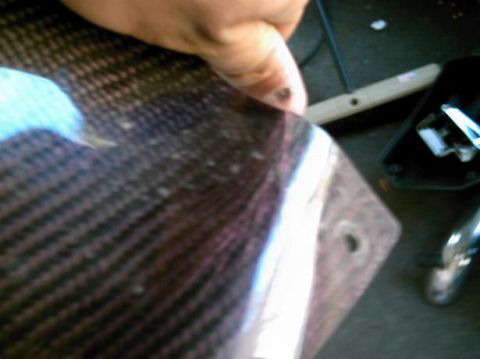 1986 Ford Bronco - Hand holding a carbon fiber panel, possibly for a vehicle.