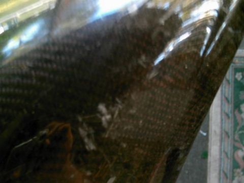 1986 Ford Bronco - The image shows a close-up view of a carbon fiber material, with a distinct woven pattern visible.