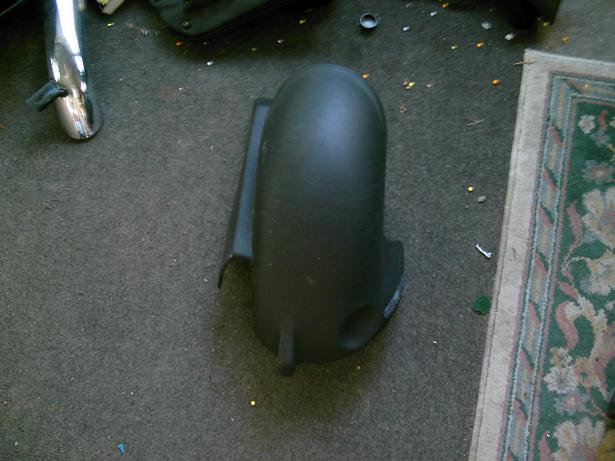 Black plastic fender part on carpeted floor
