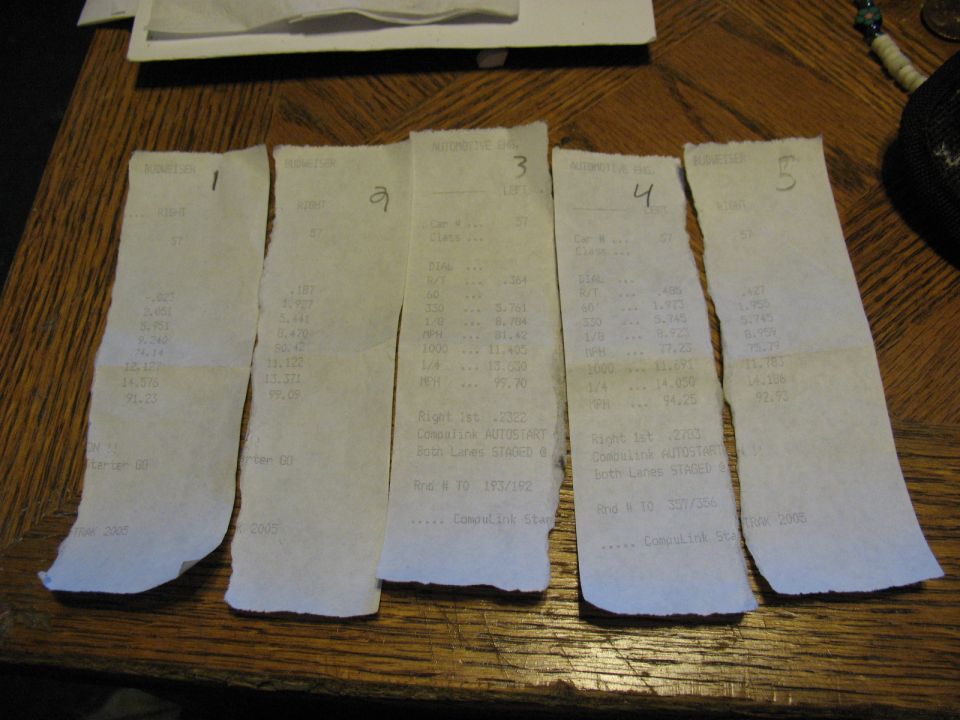 Five numbered drag racing timeslips for car #57 arranged on a wooden table showing ETs and MPH.