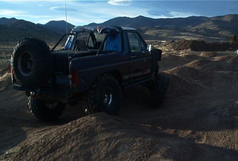 1986 Ford Bronco - This 1986 Ford Bronco navigates a challenging off-road course under a clear sky.