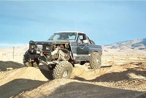 1986 Ford Bronco - Modified 1986 Ford Bronco tackling rough terrain on a sunny day.