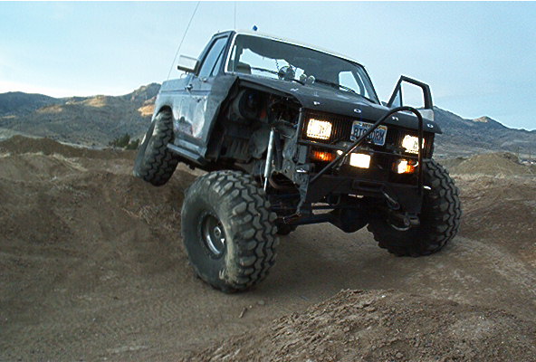 Modified 1986 Ford Bronco off-roading, front 3/4 view