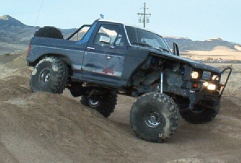 1986 Ford Bronco - Modified Ford Bronco navigating rough terrain during an off-road excursion.