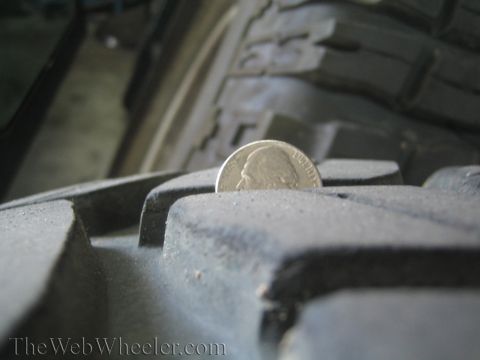 1968 Ford Mustang - A nickel is used to measure the tread depth of a tire.